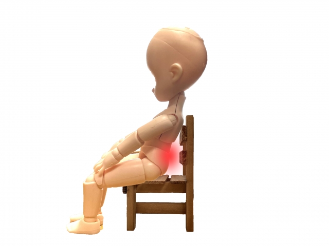 腰が疲れている、椅子に座った人形